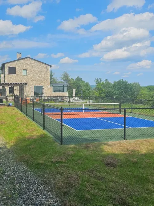 Newly constructed pickleball court with 4 black steel fence. Surface Decoturf.